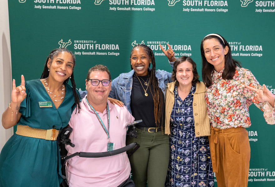 Dr. Ulluminair Salim, Kyle Romano, Dr. Catherine Wilkins, and two additional guests share a photo at the Grand Challenge: Night at the Museum live event in the Judy Genshaft Honors College.