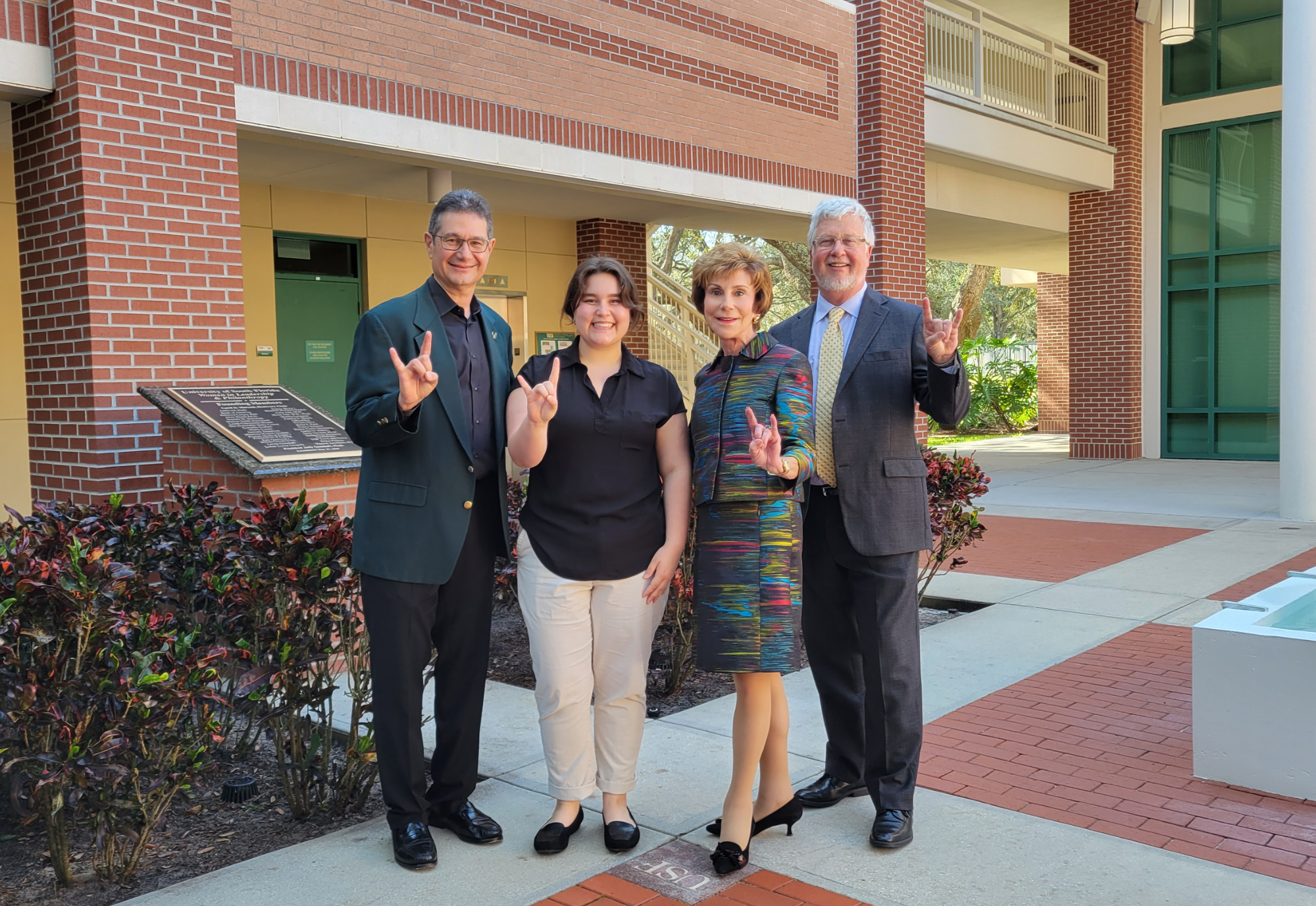 Reni Poston-Hymel posing with President Emerita Judy Genshaft, Dean Charles Adams, and Steven Greenbaum.