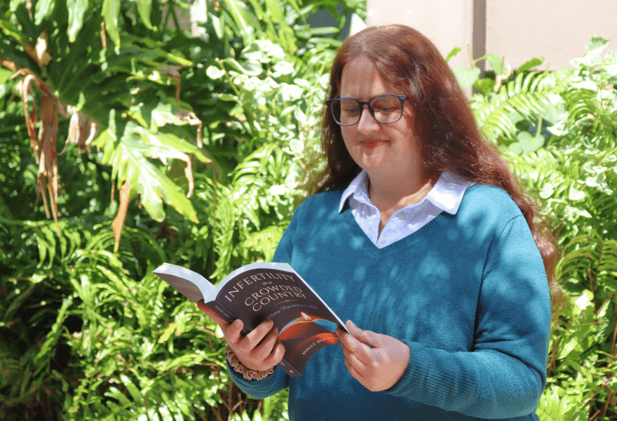 Holly Singh reading outside