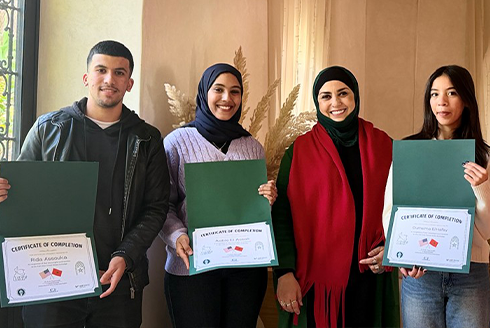 Raja Benchekroun and three students show off certificates of completion.