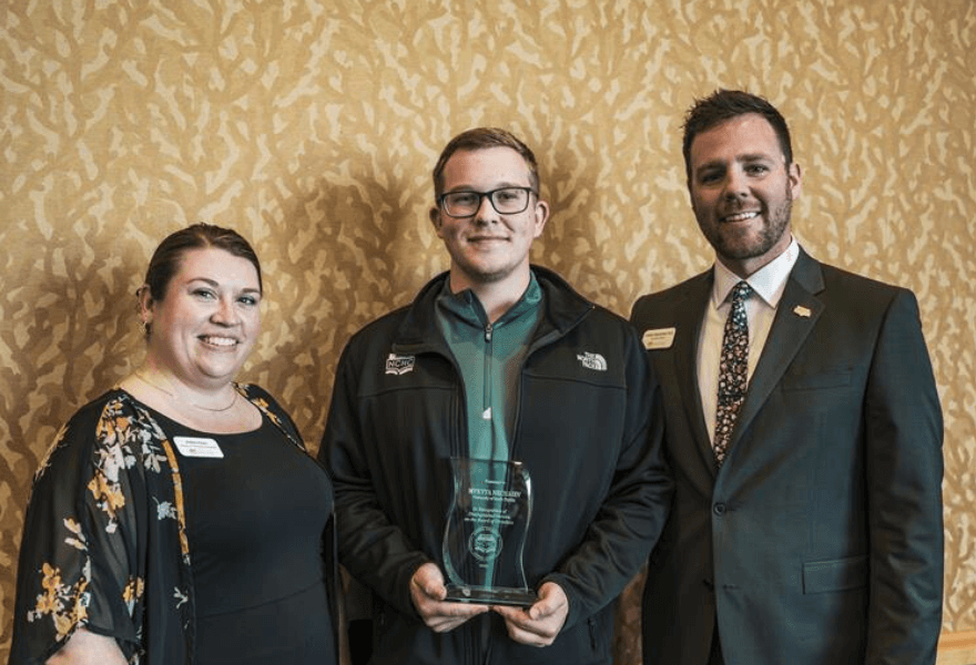 Mykyta Nechaiev holding award next to members of the NCHC