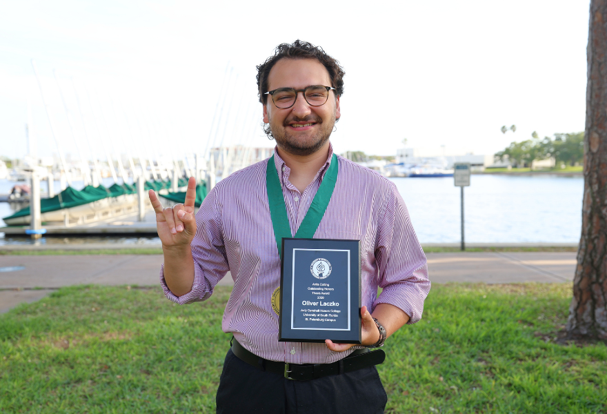 Oliver Laczko with Outstanding thesis award by water