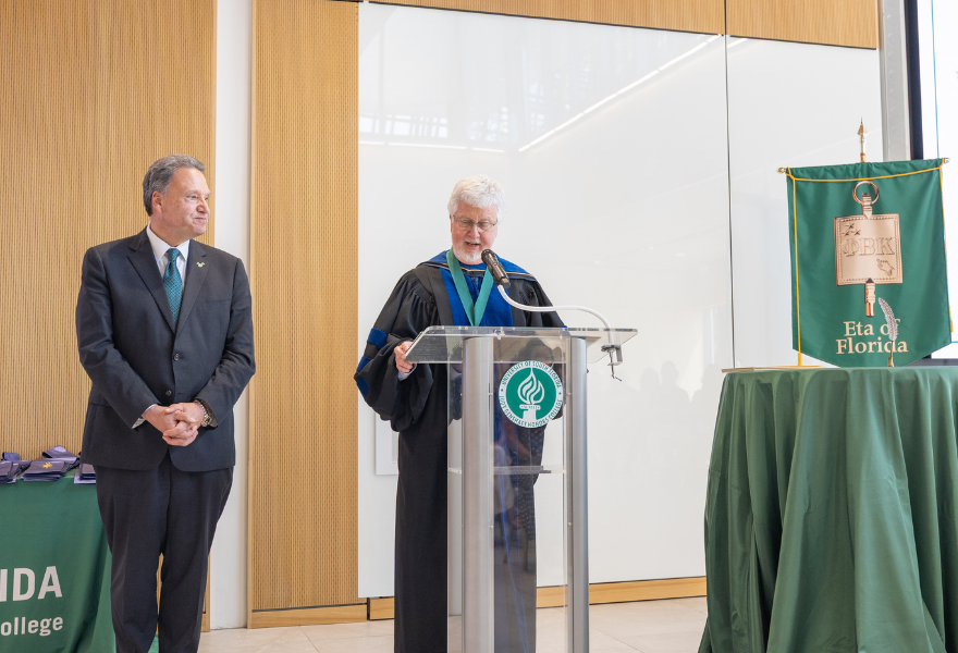 President Moez Limayem and Dean Charles Adams at the podium in the Honors atrium