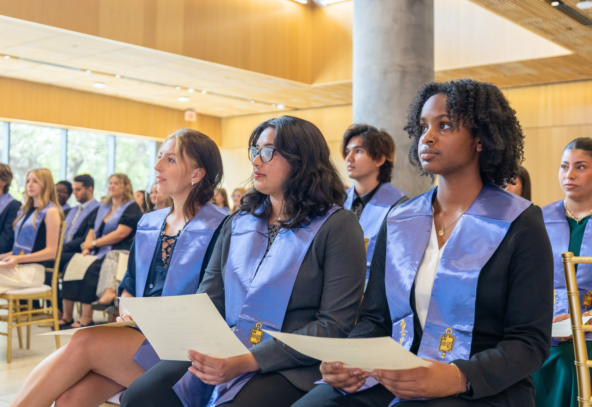 Phi Beta Kappa inductees sitting in Honors atrium with their stoles