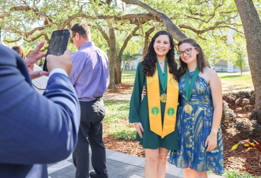 A graduate and friend get their photo taken