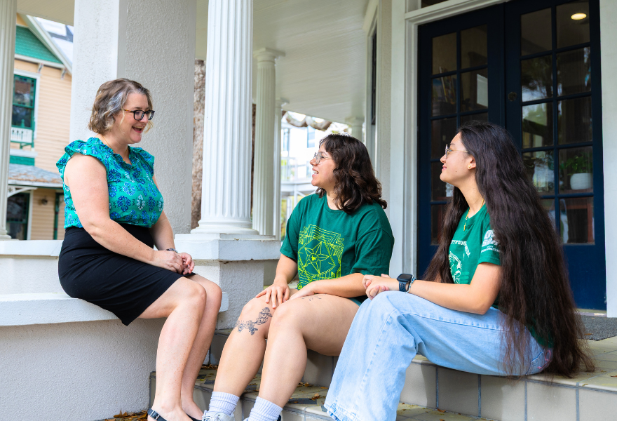 Judy Gensahft Honors College Assistant Dean Cayla Lanier talks with two students on steps of Snell House