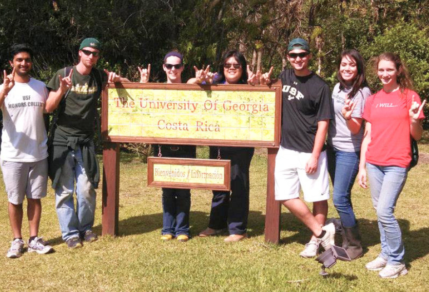 Sy-Woei Hao and other Honors students standing in front of the Unviersity Of Georgia sign in Costa Rica