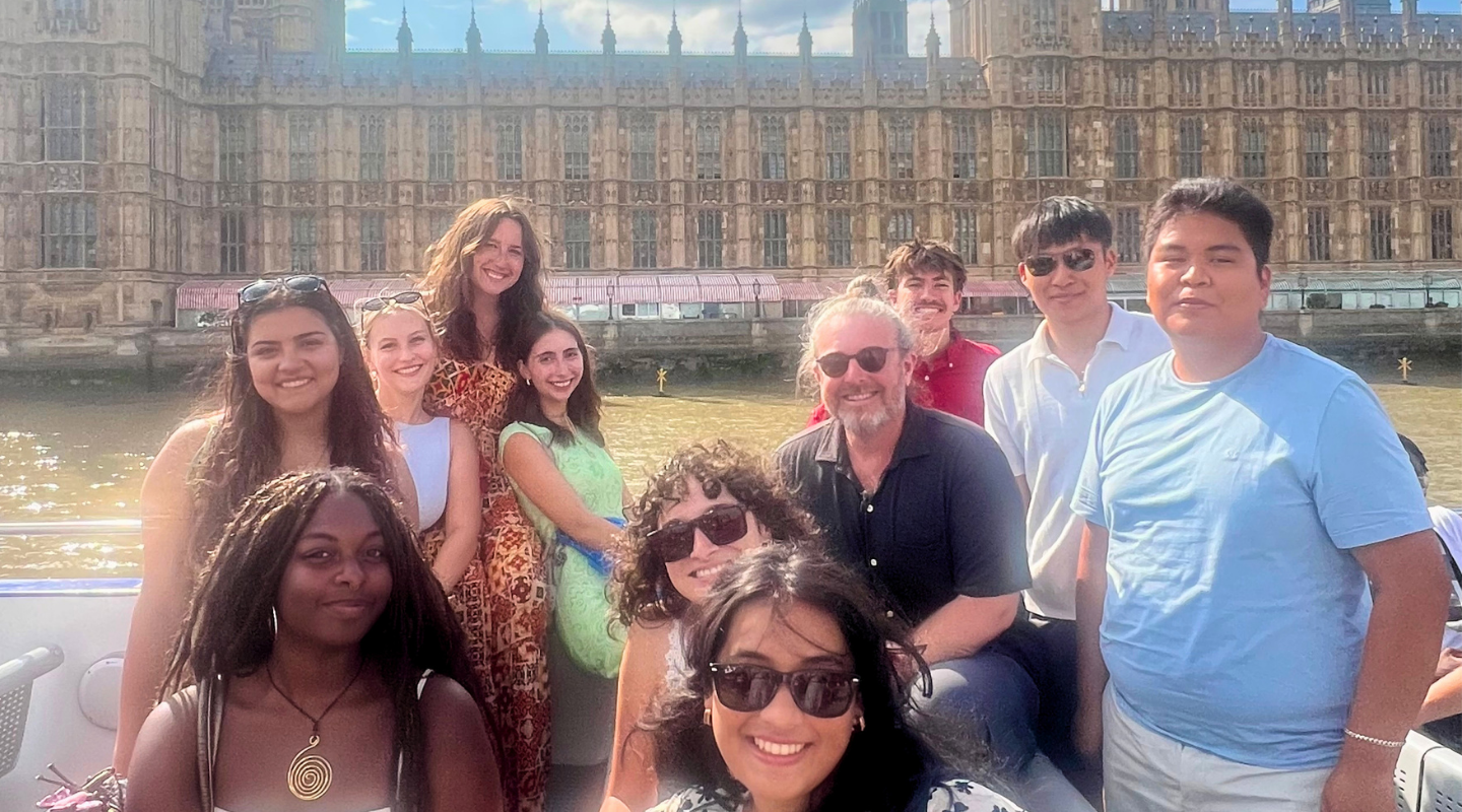 Dr. Young and students on boat on river Thames in front of Parliament building