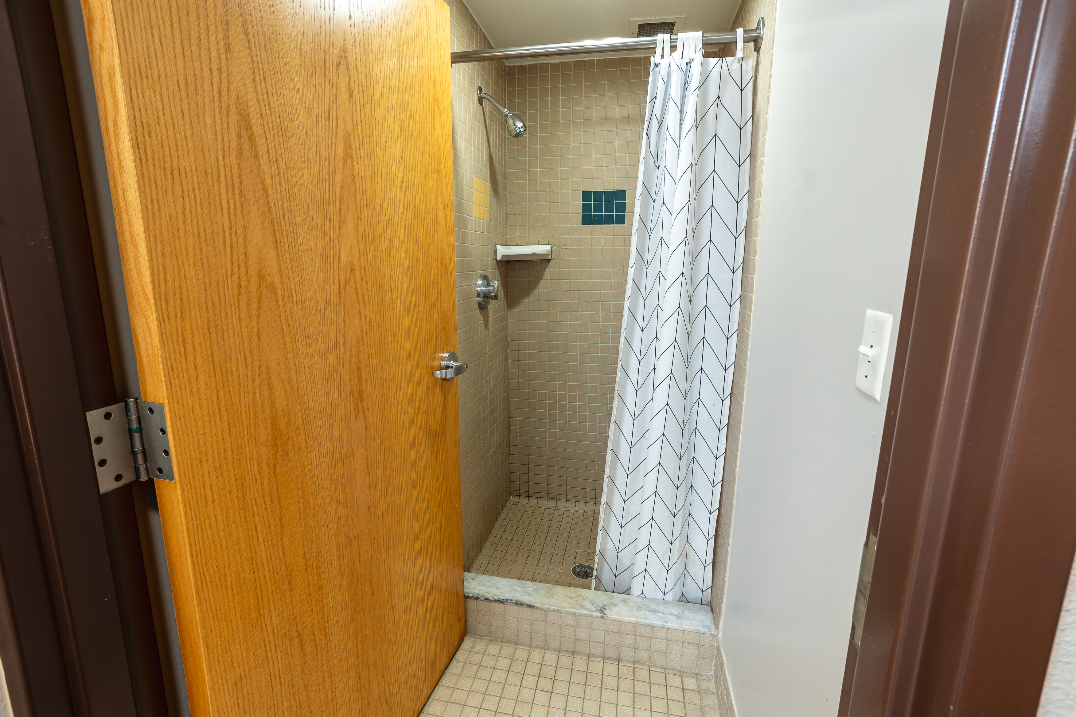 Shower on right side. Two towel racks on the wall.