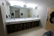 three bathroom sinks with large mirror and cubbies below