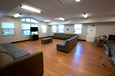 common area with three large couches and two tables with chairs