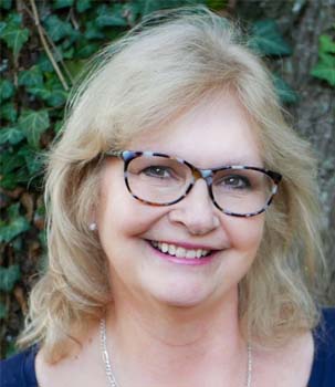 Portrait of Peg wearing glasses and smiling