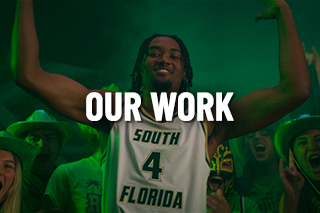 a usf basketball player stands with his hands up with the words our work embedded on the image