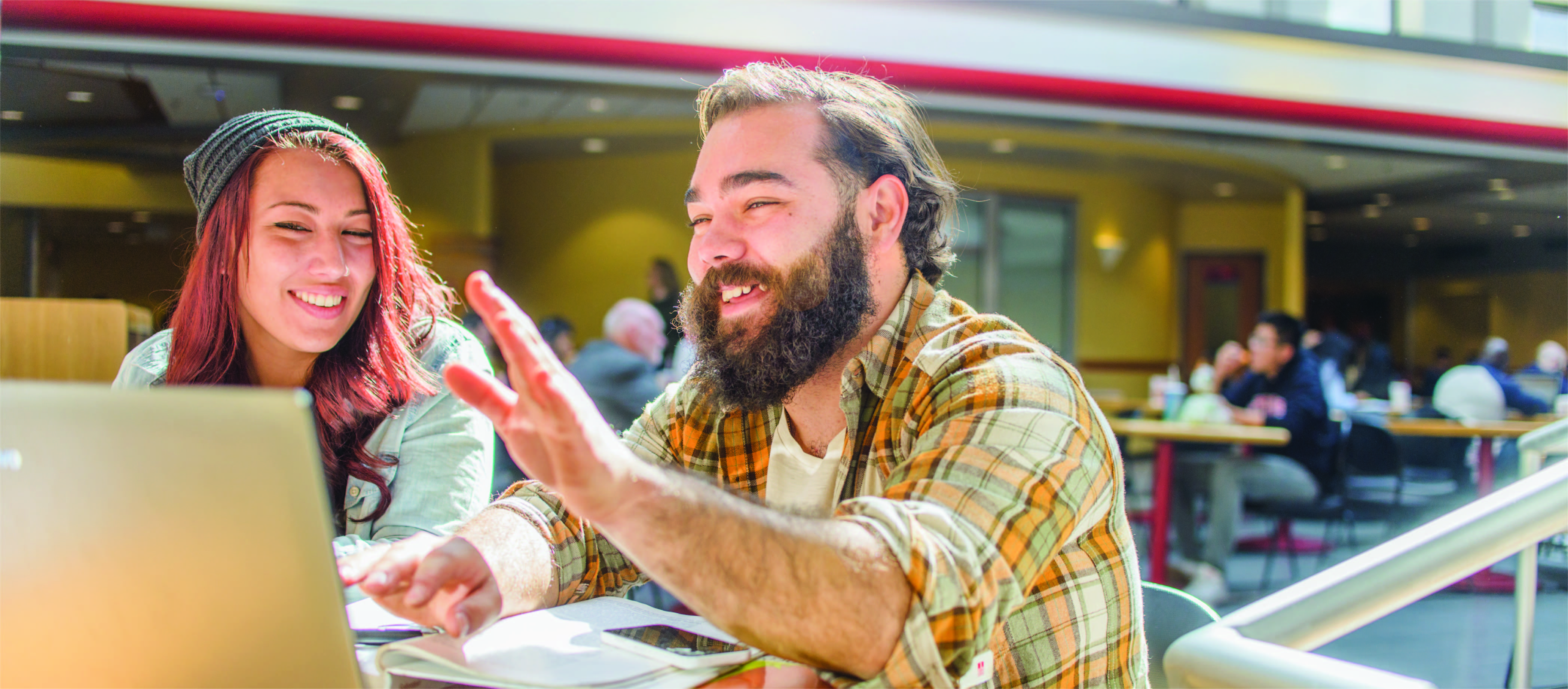 students studying together at a café to complete their online graduate degrees