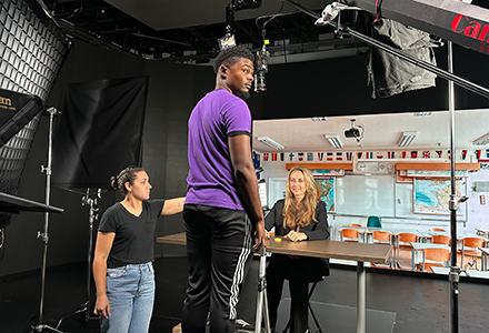 Professor Sarah van Ingen Lauer sits at desk in studio to film