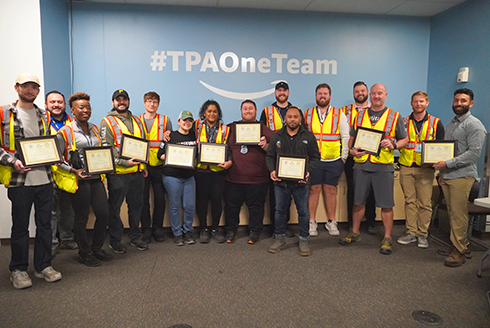 Group of Lean Six Sigma graduates pose with their new certificates. 