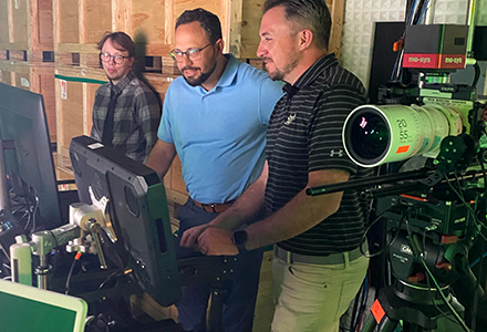 john stands and talks to two usf ined employees in studio
