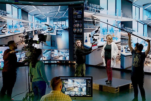 an inside look at ined studios in front of the vue wall with cameraman/boom operators and actors