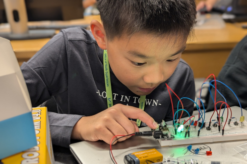 Middle school student wiring a breadboard.