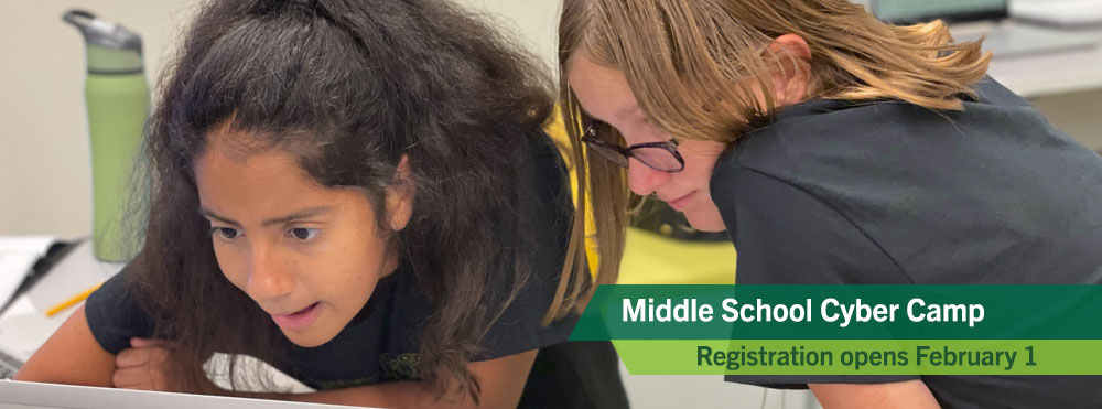 two campers concentrate on a cybersecurity camp activity at Middle School Cyber Camp. Registration for all camps opens on February 1.