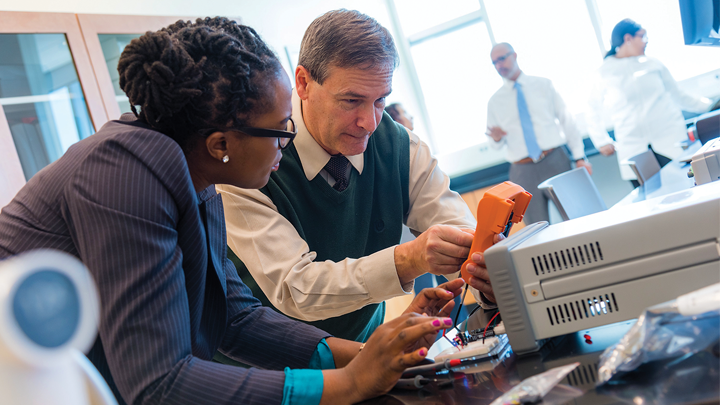Robert Frisina, center, works with Olukemi Akintewe in the USF Global Center for Hearing Research