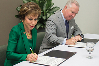 Judy Genshaft and Bob Buckhorn signing papers
