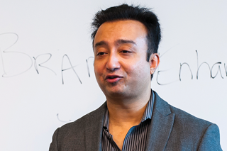 Marketing professor, Dipayan Biswas, standing in front of a whiteboard