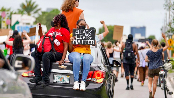 Picture of BLM protesters sitting on the back of a car
