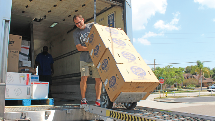 Chris Scott, co-owner of Belleair Market, unloads supplies from a box truck
