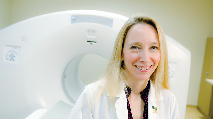 USF director smiling in front of an MRI machine