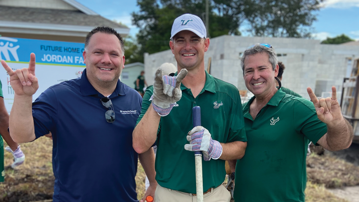 From left, Mike Sutton with USF Football Coach Jeff Scott and and Habitat sponsor Jeffrey Fishman, ’92, Life Member.