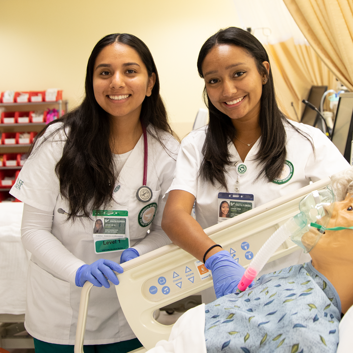 Photo of two nursing students smiling at the camera.