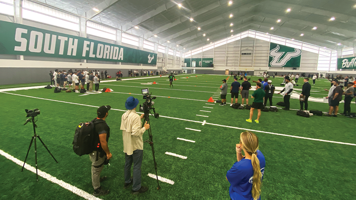 Professional team scouts watch Bulls football players work out inside the new Porter Family Indoor Performance Facility during USF Pro Day.