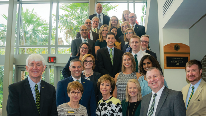 A delegation of 25 USF personnel gathered on a staircase at UCF at a Florida Board of Governors meeting.