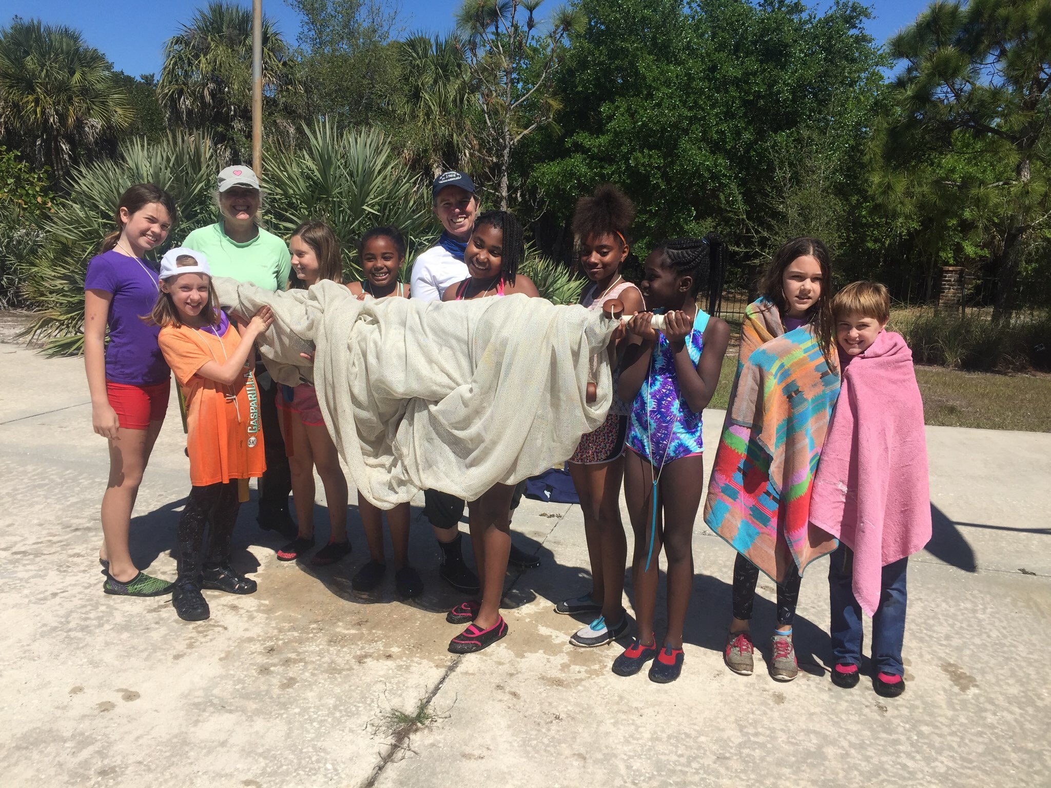 Elementary students holding seine net after catching fish