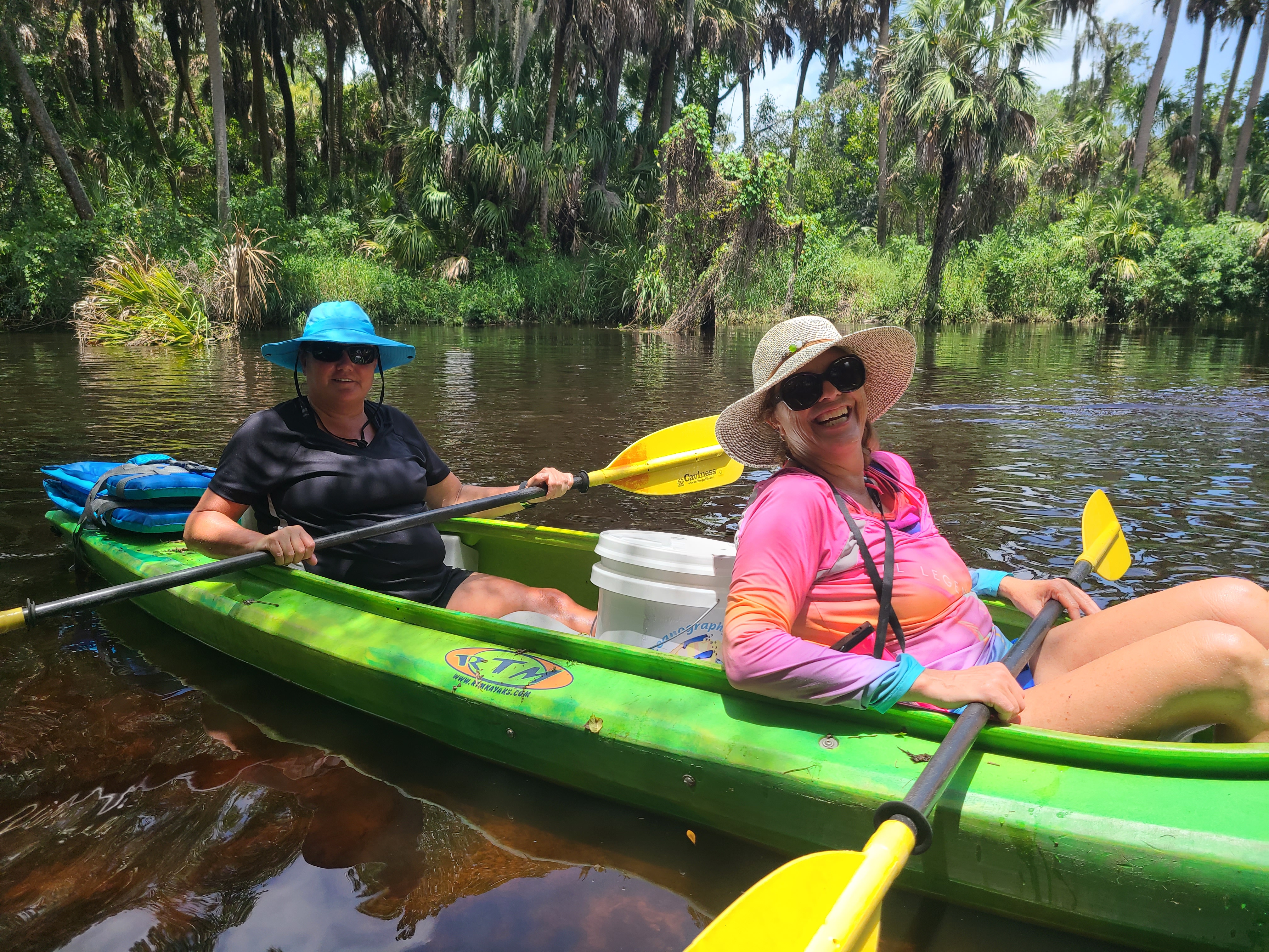 Two teachers kayaking in green kayak down little manatee river.