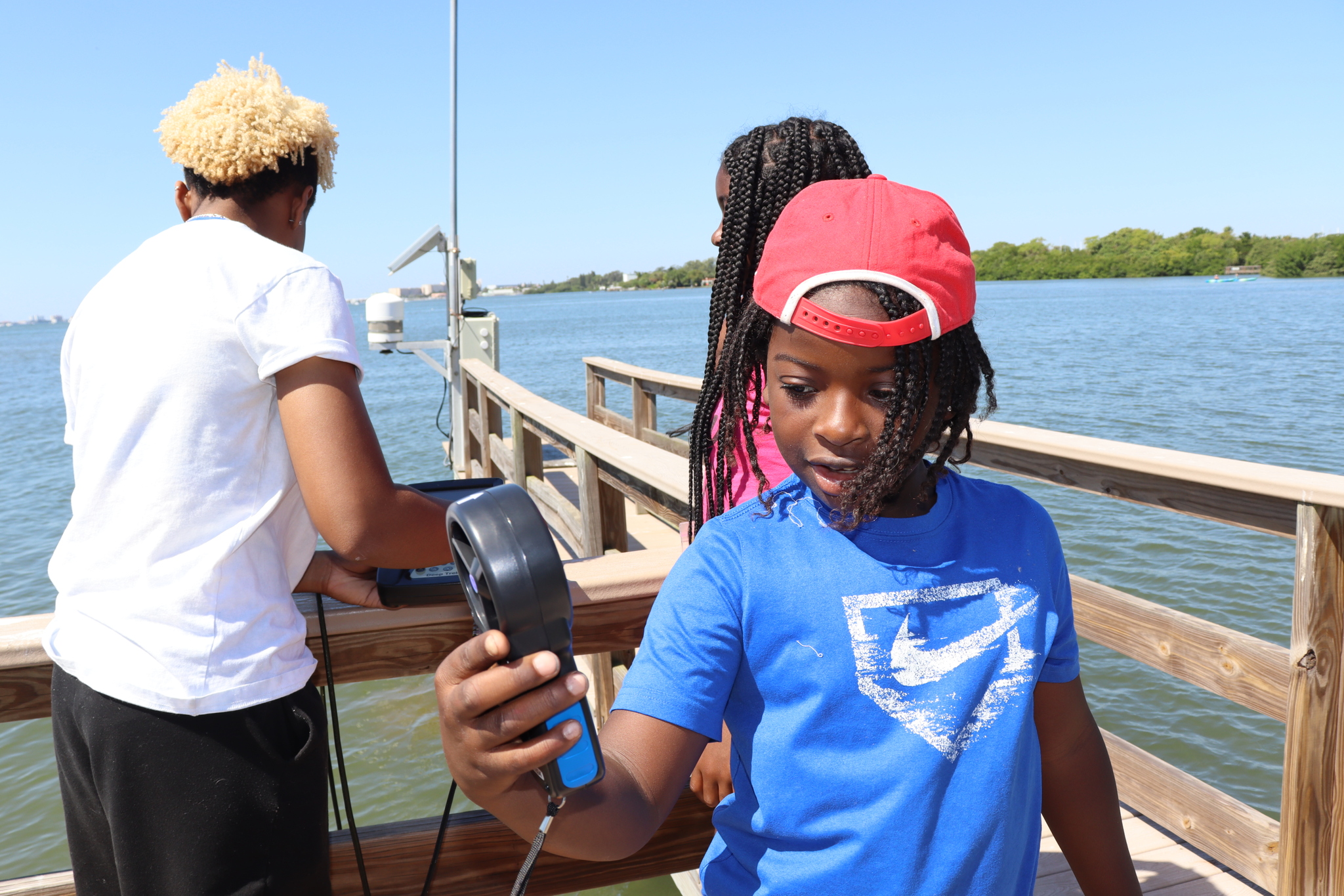 Student taking wind measurements on dock