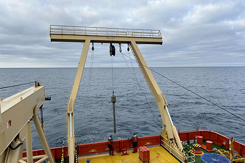 A kasten core coming up on the back deck. That red box is what the Marine Technicians (MTs) use to rest the core barrel on while they secure the weight stand.