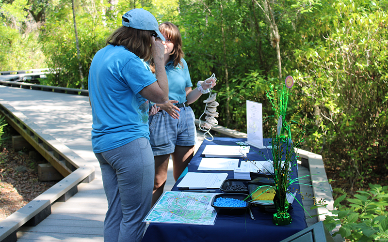 Blondheim talking with a participant who joined the Gulf Shellfish Institute’s Citizen Science Program. At the Booker Creek Preserve outreach event, they built a vertical oyster garden to install on their dock at home. PHOTO CREDIT: Jess Van Vaerenbergh.