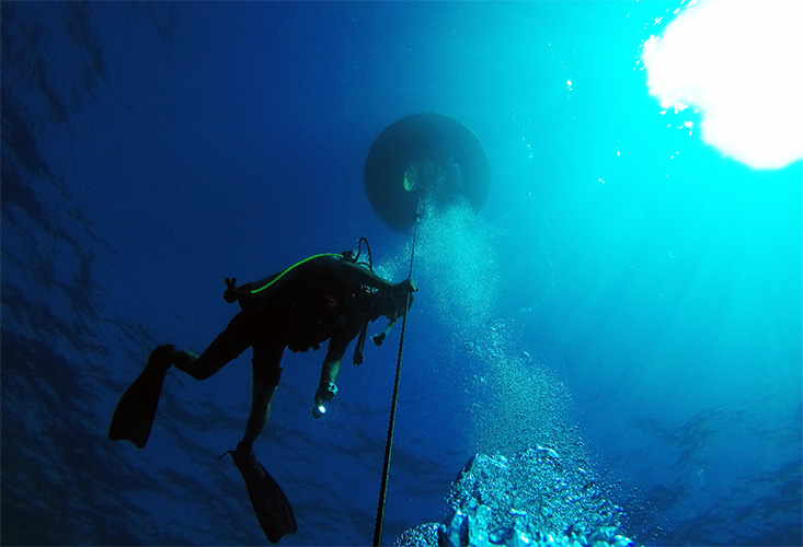 Chief Scientist, Jay Law, captures this photo as he examines the buoy and mooring line.