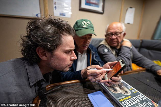 David Mearns, seen here in a USF hat while reviewing a sonar image of the shipwreck, credits his expertise to the skills he learned while studying marine science at USF. Credit: Royal Canadian Geographical Society.