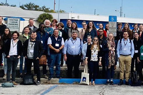 Participants of the Ecopath35 conference pose for a group photo on the seawall at the College of Marine Science. 