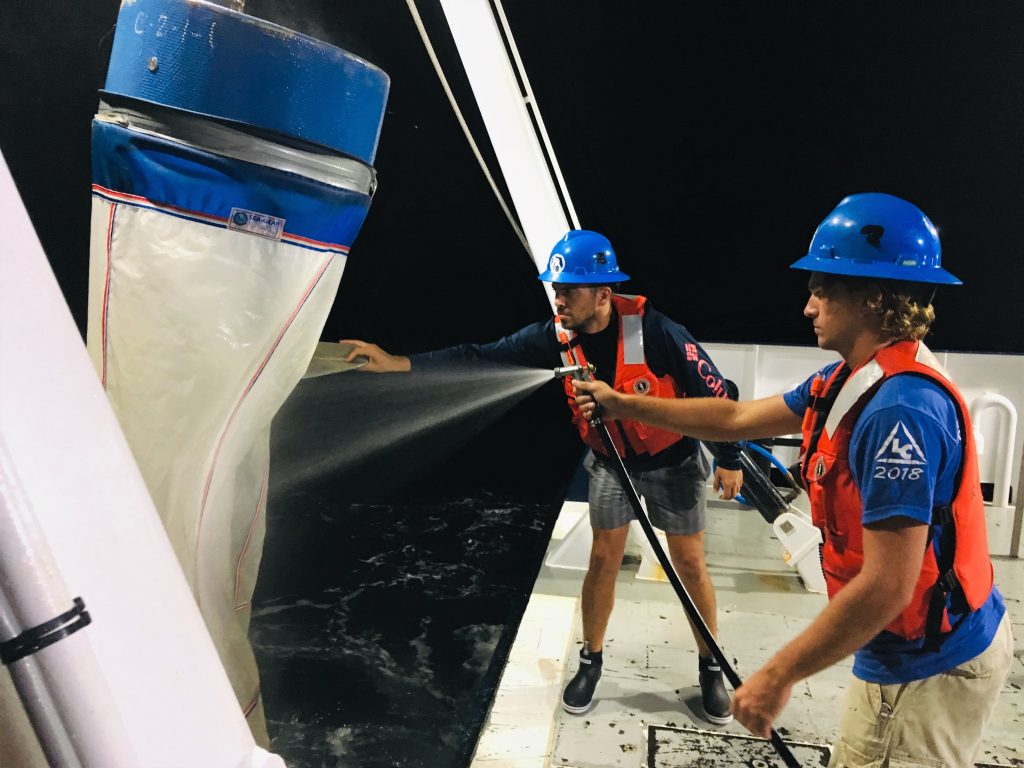 Garrett Miller (foreground) and Ian Williams retrieve and hose down the Bongo nets at the last station on one of their noon to midnight shifts.