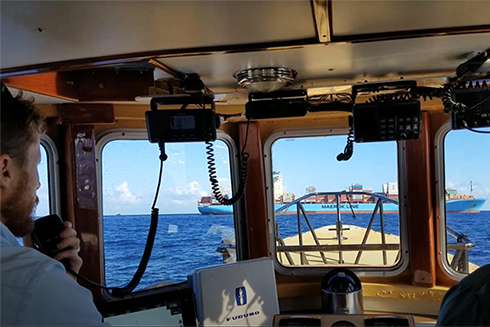 Harbor pilots, specialized in directing vessels in and out of harbors, approach an incoming ship to guide it into port in Miami.