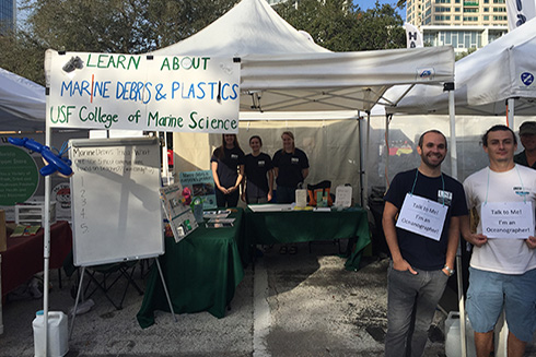 USF CMS graduate students, Luis Sorinas, Juan Millan, Becky Scott, Shannon Burns, and Maddie Schwaab, at the CMS outreach booth, excited to teach the public about marine debris.