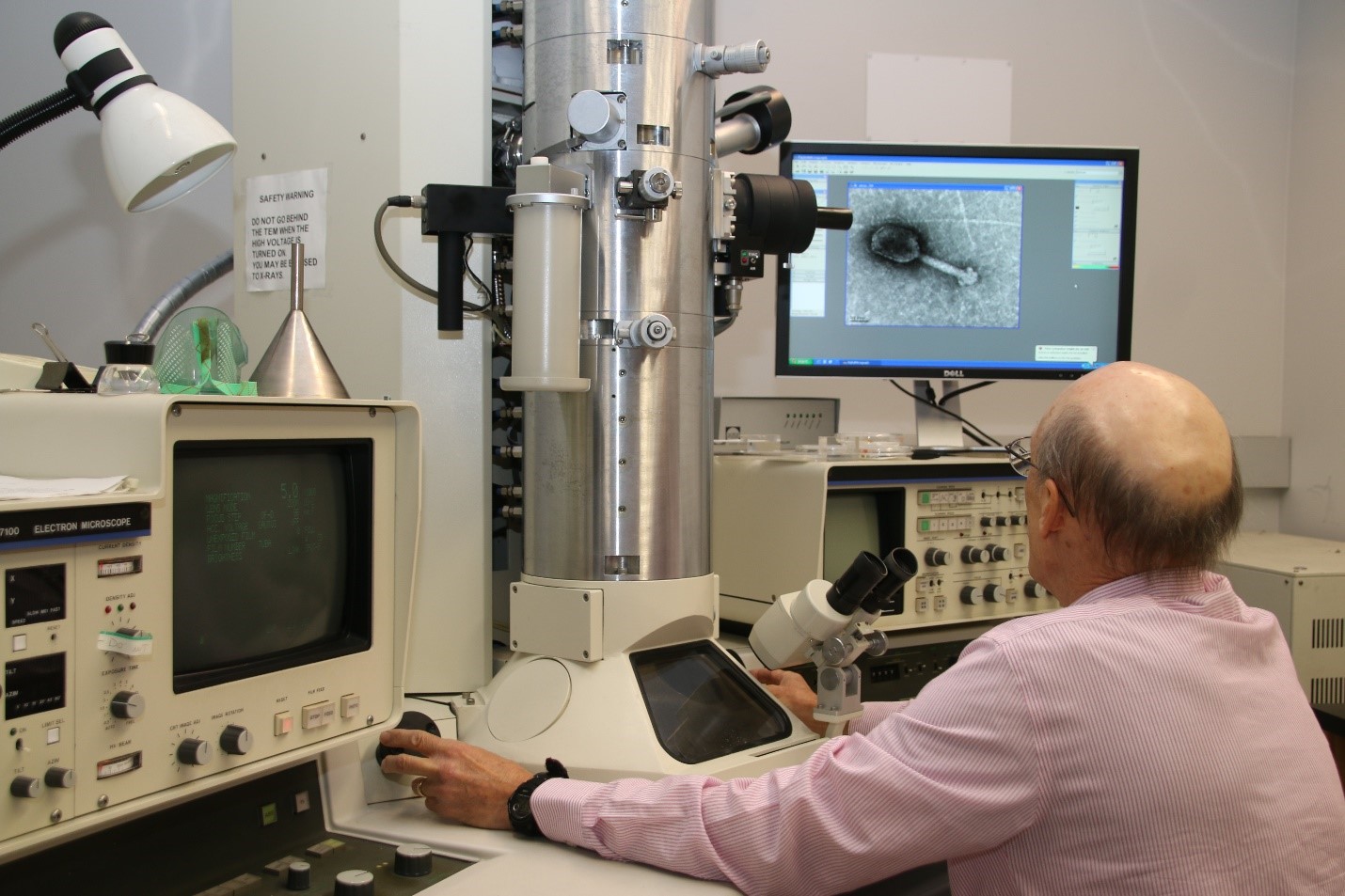Manning the TEM station, Tony Greco looks at an image of an individual virus.