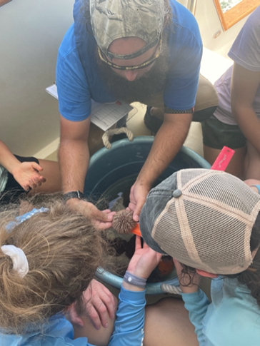 Mike Sipes goes through the otter trawl catch with campers