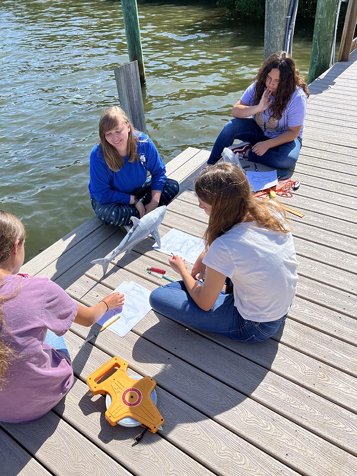 Science Mentor Savanna teaching the campers using her 3D printed shark model. 