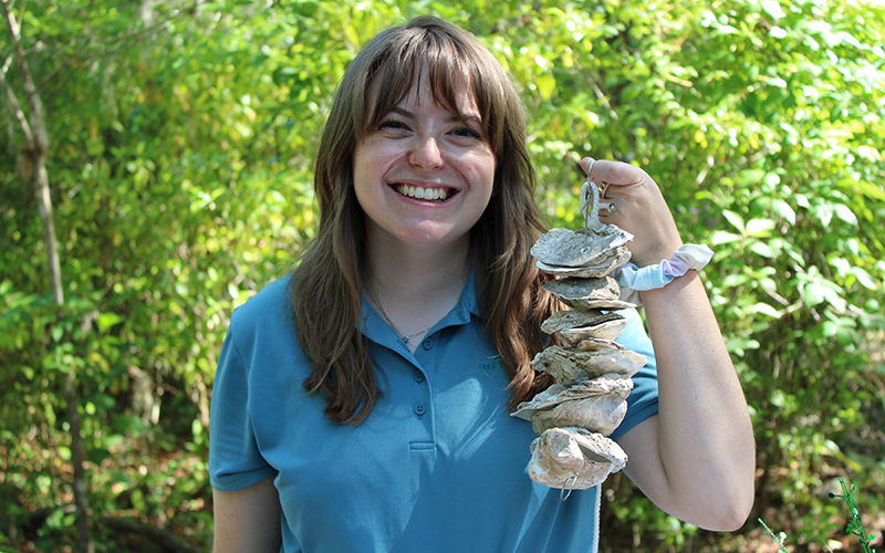 Image - Large with Caption Image Dimensions - Width: 720 px, Height: 400 px* * Recommended Height.   Blondheim holding a vertical oyster garden that was built at the latest outreach event at Brooker Creek Reserve. PHOTO CREDIT: Jess Van Vaerenbergh.