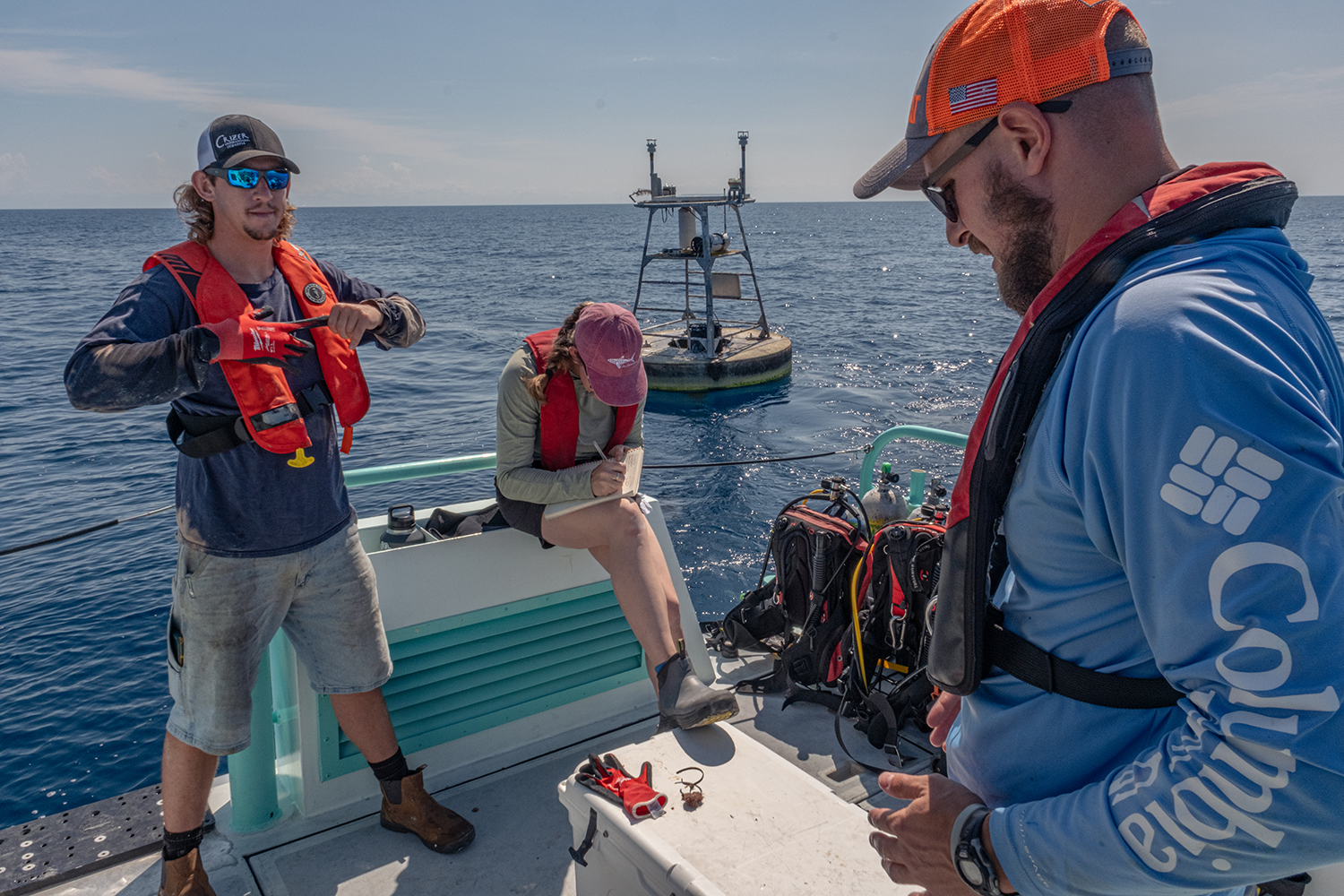 Orion Scharton-Witmer, Sam D’Angelo, and Mitch Lemon service buoys in the Gulf. Credit: Jackson Sullivan
